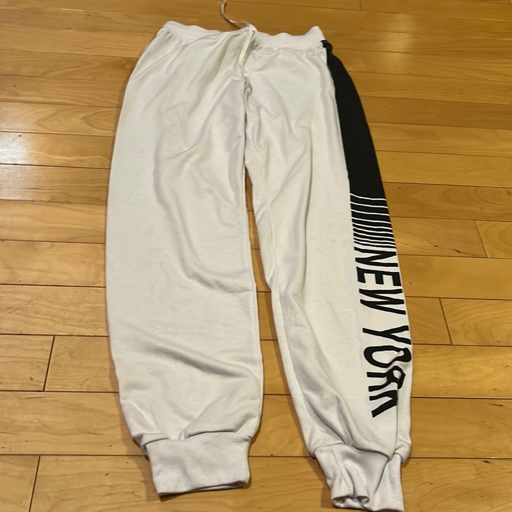 White sweatpants with the wording New York on the side size small